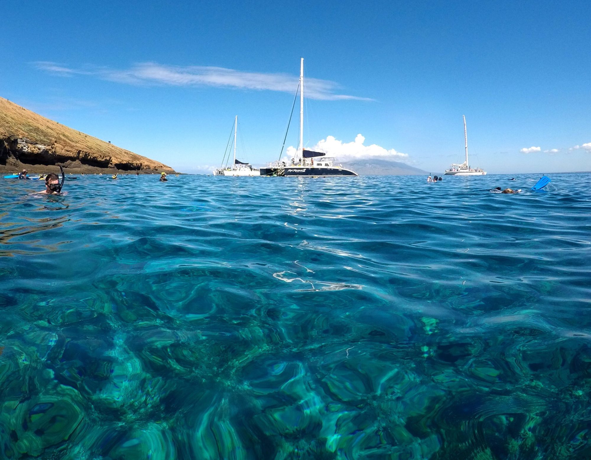 Snorkelers at Molokini Crater with the Kai Kanani II catamaran in the background