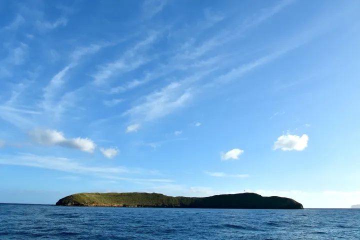 a large body of water with a mountain in the background
